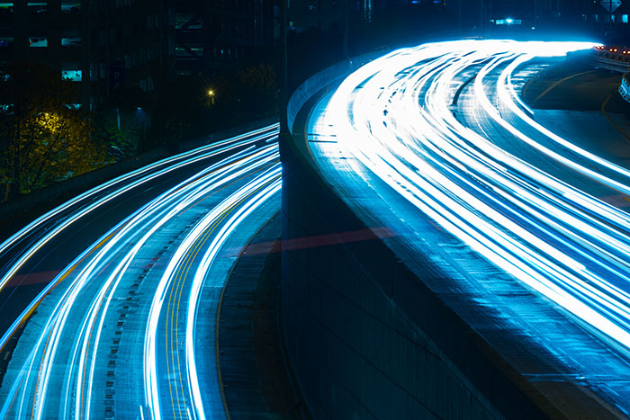 Long exposure blue lights highway split road concept - Jaguar Freight